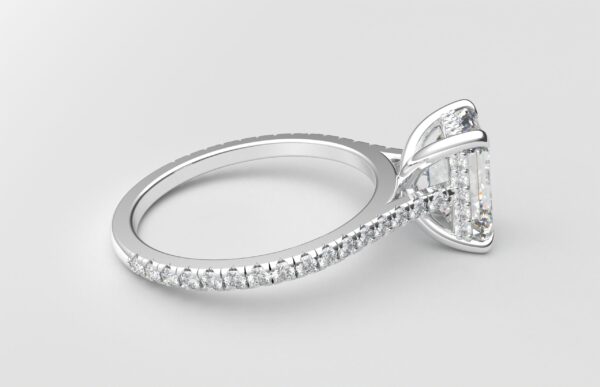 side view Cathedral setting emerald cut diamond with hidden halo ring with a simple prong setting in white gold color and french paved diamonds band