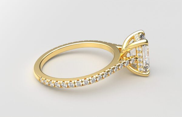 side view Cathedral setting emerald cut diamond with hidden halo ring with a simple prong setting in yellow gold color and french paved diamonds band