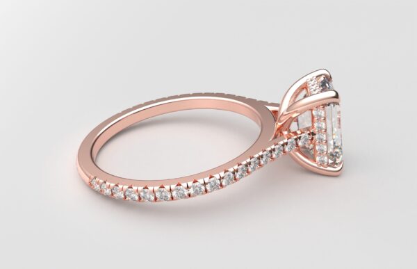 side view Cathedral setting emerald cut diamond with hidden halo ring with a simple prong setting in rose gold color and french paved diamonds band