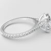 side view cathedral setting oval cut diamond with hidden halo ring with a simple prong setting in white gold color and french paved diamonds band