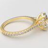 side view cathedral setting oval cut diamond with hidden halo ring with a simple prong setting in yellow gold color and french paved diamonds band