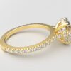 side view modern oval cathedral setting diamond with hidden halo ring with a classic prong setting in yellow gold color and french paved round diamonds band