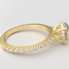 side view modern round cathedral setting diamond with hidden halo ring with a classic prong setting in yellow gold color and french paved round diamonds band