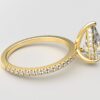 side view pear diamond with hidden halo ring with a classic 3 prong setting in yellow gold color and french paved diamond band