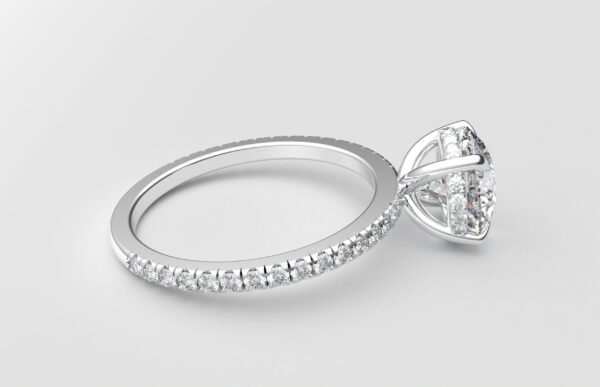 side view of round diamond with hidden halo ring with a classic 4 prong setting in white gold color and french paved diamond band