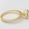 side view of round diamond with hidden halo ring with a classic 4 prong setting in yellow gold color and french paved diamond band