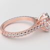 side view modern catherdral setting french pave oval diamond ring in rose gold with a hidden halo