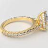 side view modern catherdral setting french pave pear diamond ring in yellow gold with a hidden halo