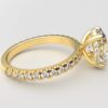 side view classic french pave oval diamond ring in yellow gold with a hidden halo