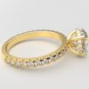 Side view classic french pave round diamond ring in yellow gold with a hidden halo