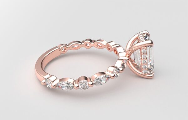 Side view Emerald solitaire diamond ring in rose gold with round and marquise diamond band hidden halo