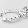 side view pear solitaire diamond ring in white gold with round and marquise diamond band hidden halo