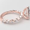 side view pear solitaire diamond ring in rose gold with round and marquise diamond band hidden halo